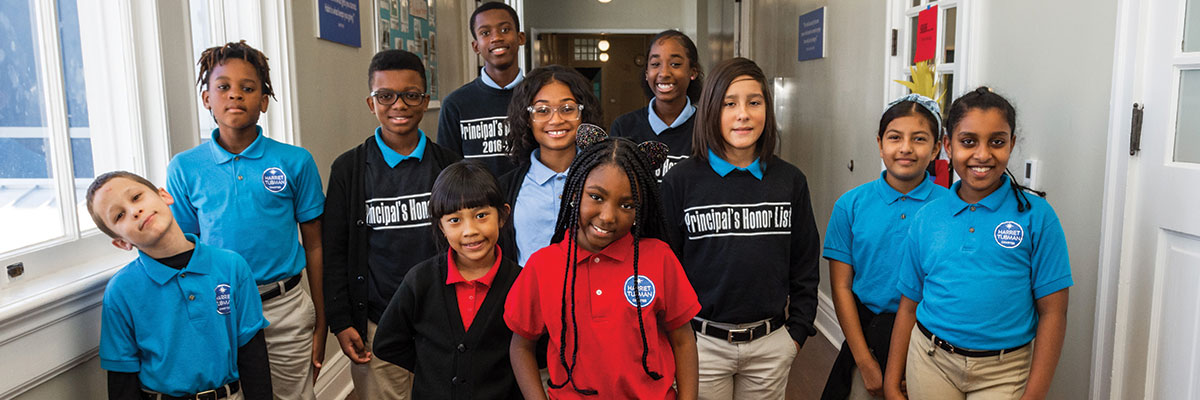 Group of smiling students posing in a hallway